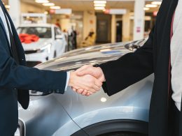 Graphic illustrating auto financing with bad credit, featuring a person with a concerned expression reviewing financial documents, a credit report with a low score, and a car dealer handing over car keys.
