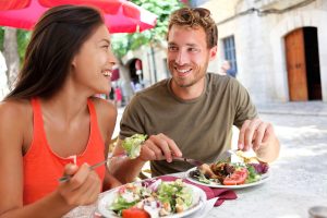 Restaurant tourists couple eating at outdoor cafe.