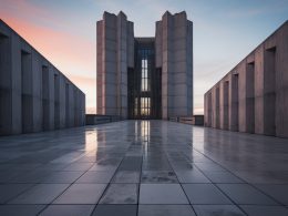 Modern concrete building with a sleek geometric design and polished surface reflecting the sunset sky