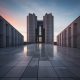 Modern concrete building with a sleek geometric design and polished surface reflecting the sunset sky